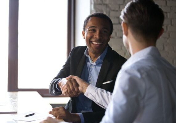 two men shaking hands at a table