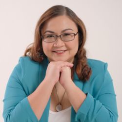 Kristine Kurly Guzman PCC headshot photo, woman with brown hair and glasses wearing a blue blazer and white top smiling