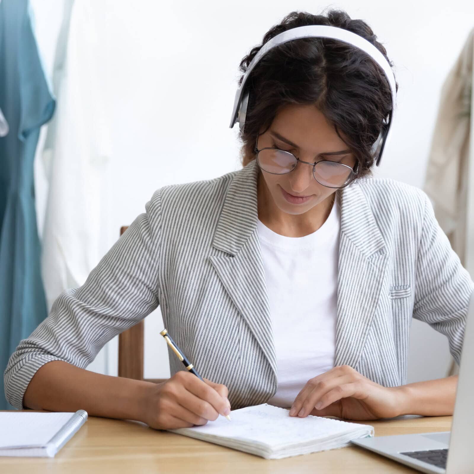 Student in a virtual coaching education session, taking notes while attending an online webinar for professional development
