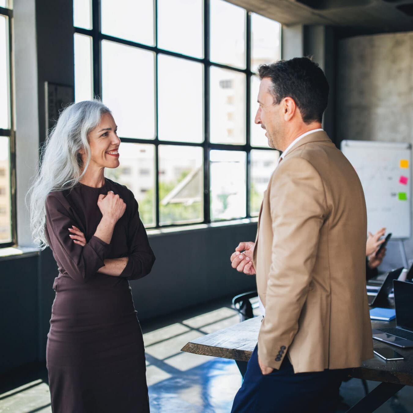 A woman and a man discuss the ICF Coaching competencies in an office setting.