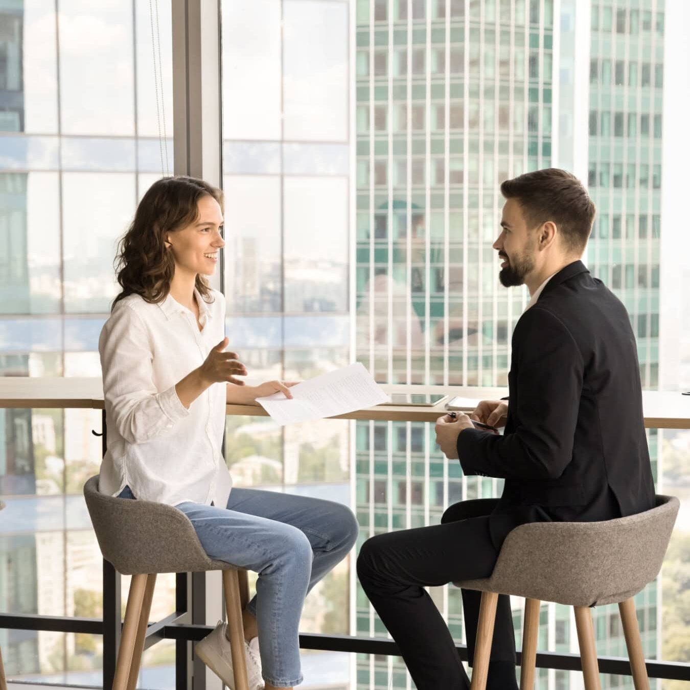 A man and a woman review the ICF credential experience requirements a table in a friendly conversation.
