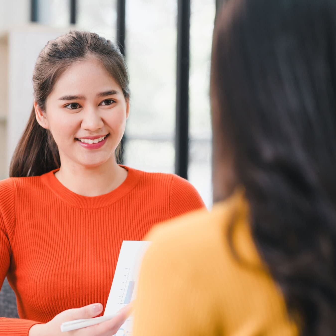 A woman mentors another woman coach.