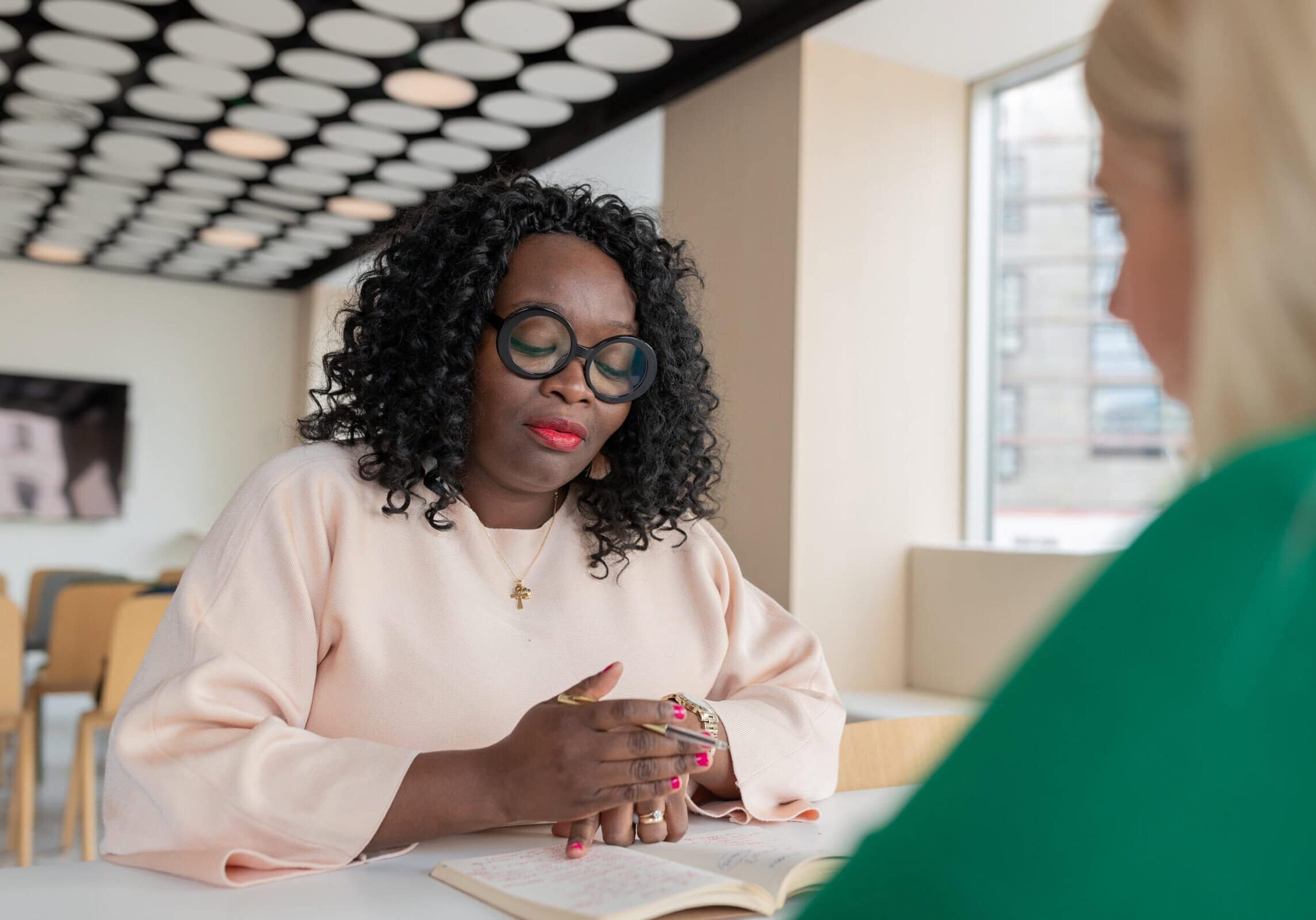 Professional ICF coach in a one-on-one coaching session, guiding a client through personal and organizational growth strategies.