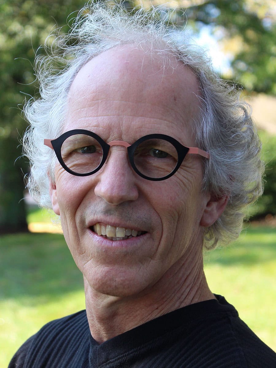 Joel DiGirolamo is the vice president of research and data science for ICF, headshot is of a man smiling with glasses on wearing a black shirt in nature.