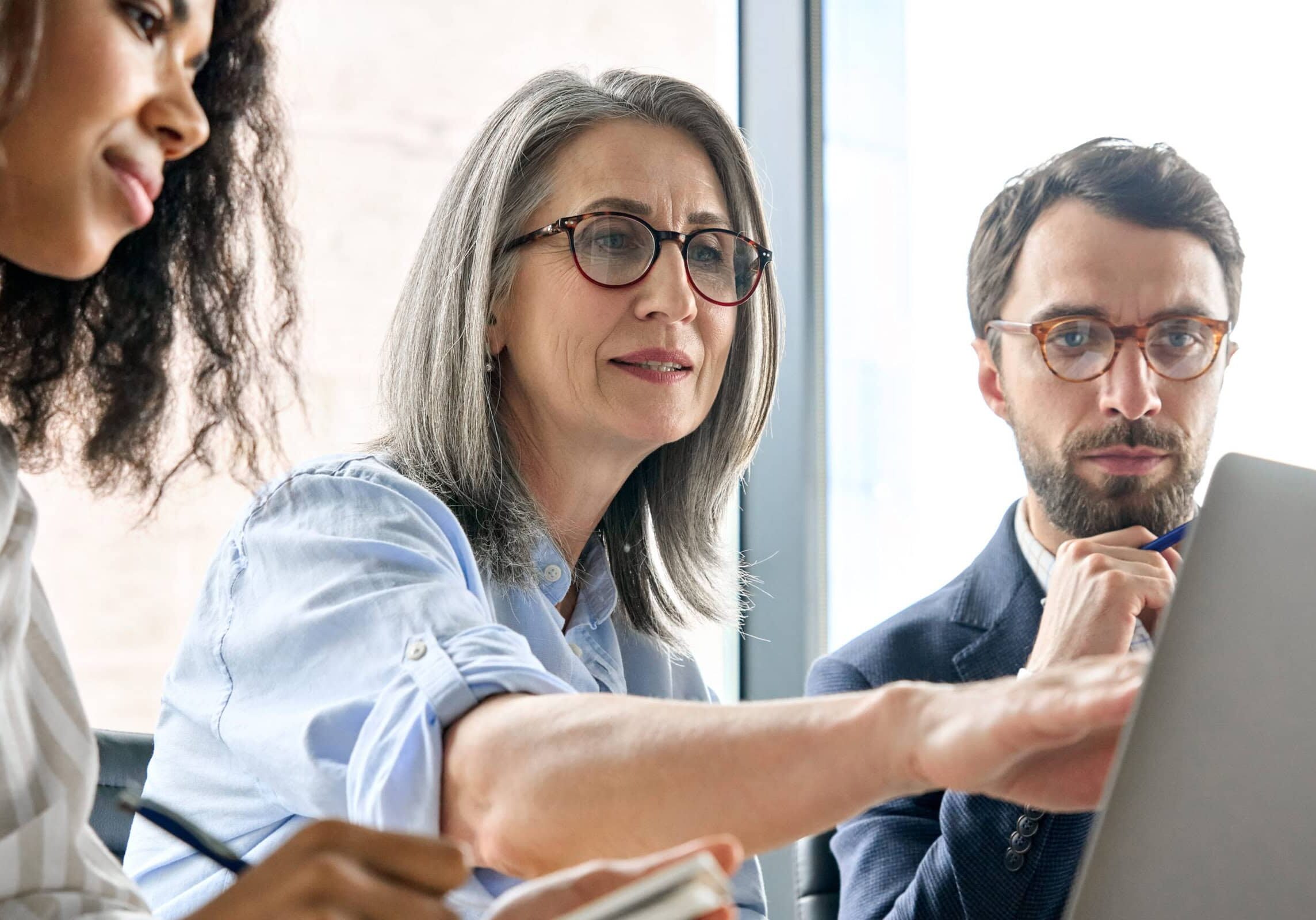 coach showing two others something on a laptop screen