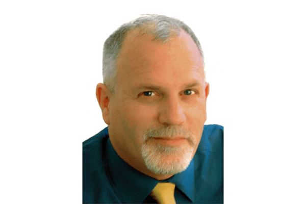 A professional headshot of Thomas Leonard, founder of the International Coaching Federation, with a confident and approachable expression.